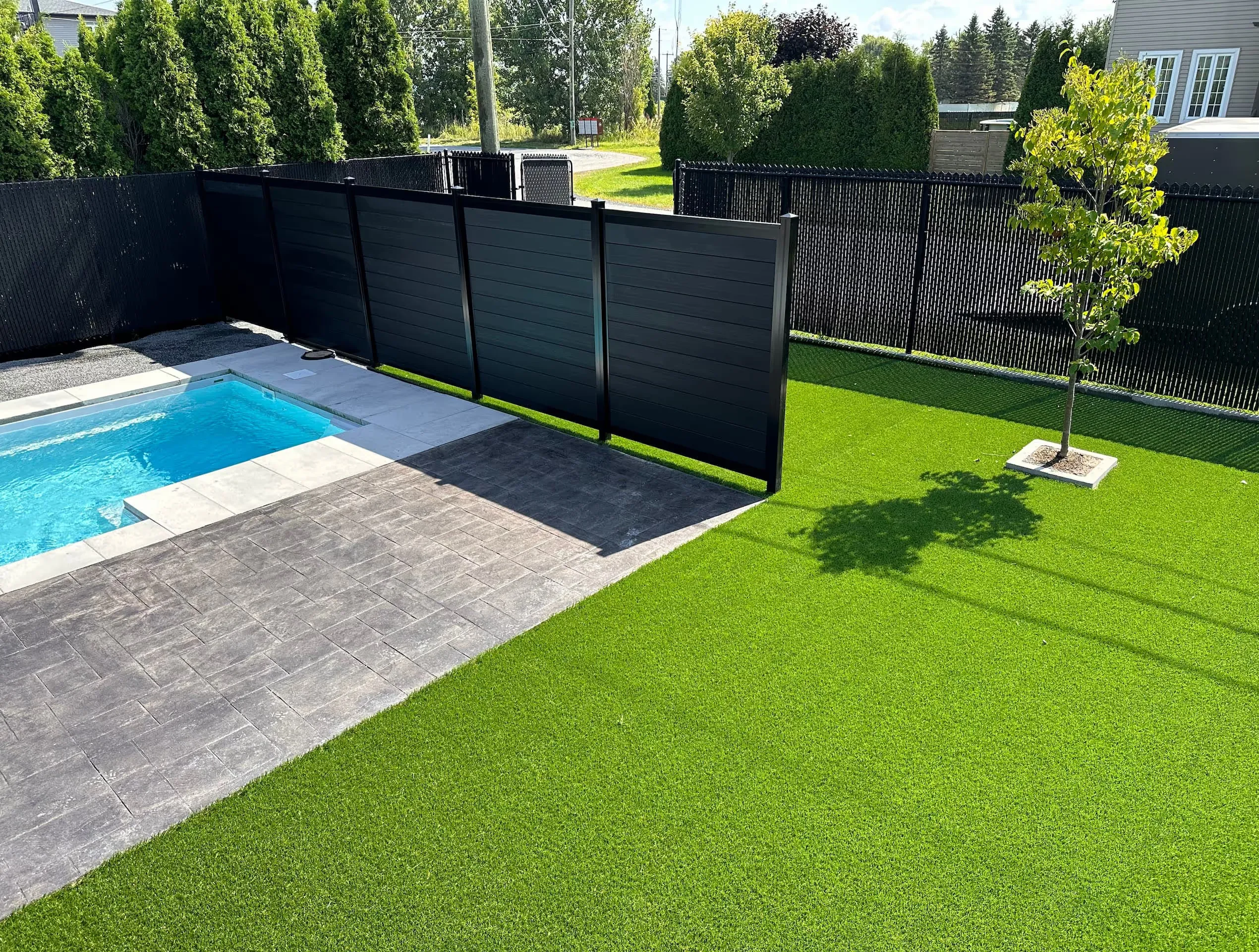 Clôture composite noire dans une cour arrière