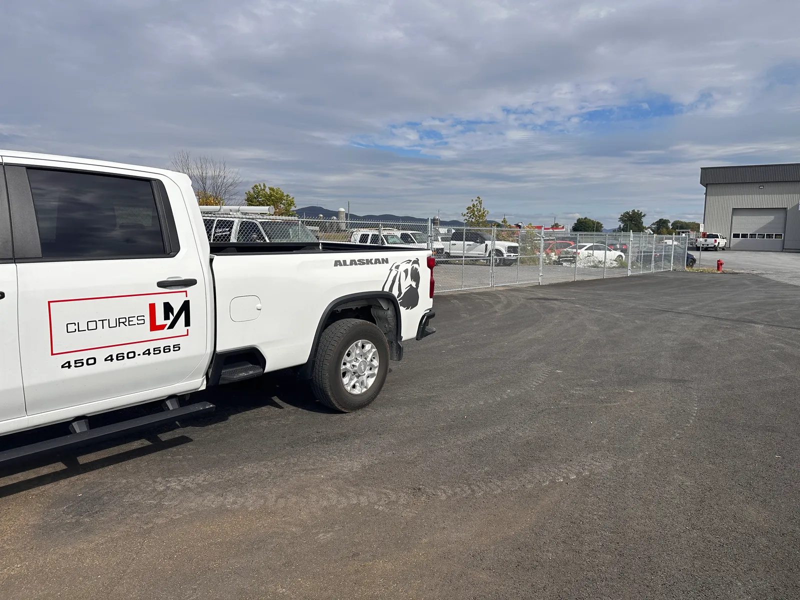Camion Clôtures LM stationné dans la cour de l'entreprise sur la Rive-Sud
