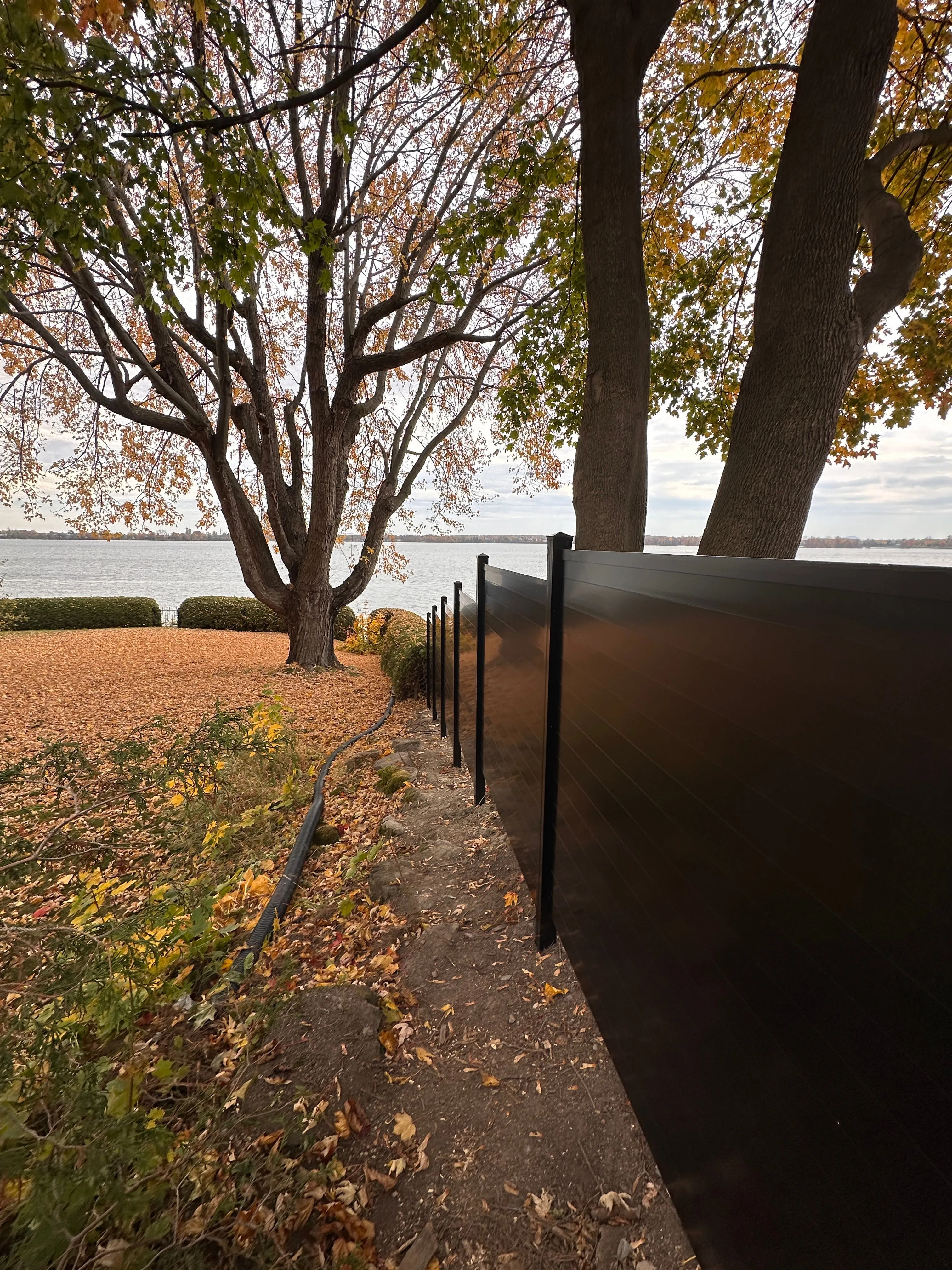 Clôture zen en aluminium le long d'un terrain en automne